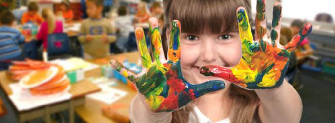 Young School Age Child Painting With Her Hands in Class
